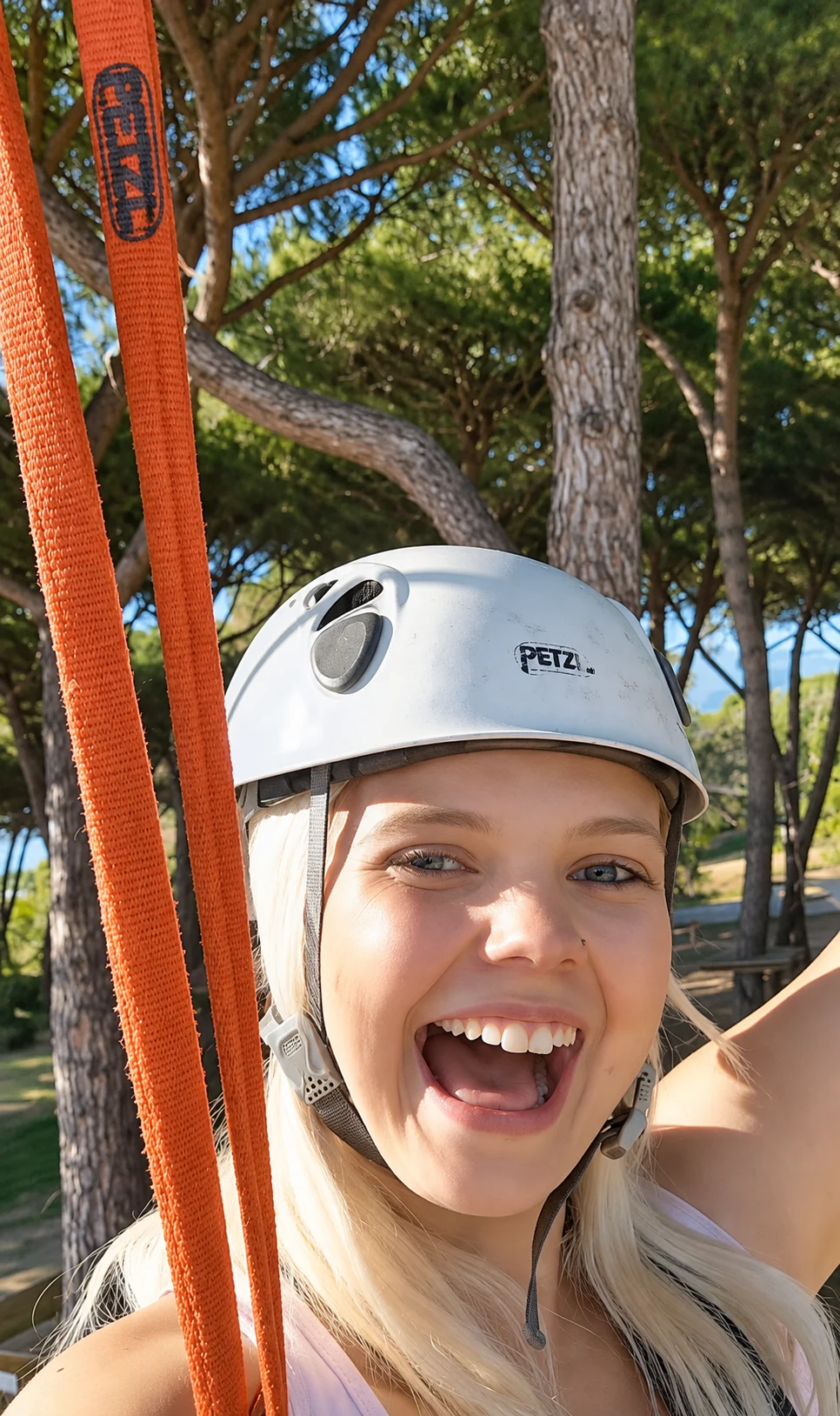 Ragazza con casco sorride felice tra i pini del percorso