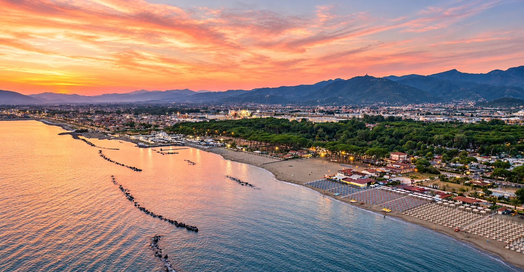 Panorama al tramonto della Riviera Apuana a Marina di Massa, con spiaggia, pineta e Alpi Apuane